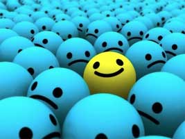 A sea of blue balls with sad faces surrounds one yellow ball with a smiley face