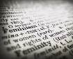 A close-up image of a dictionary, focussed on the word *Feminism* (the word *Femininity* is just out of focus below it)