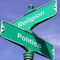 a sign post indicating a crossroads - the top sign says RELIGION, the lower sign says POLITICS