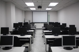 A room full of computers with a whiteboard/projector screen front and centre