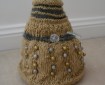 A gold Dalek with silver accents and gold and silver beads as its bobbles. The plunger and ray gun are made of a silver pipecleaner, and the eyestalk out of a gold one.