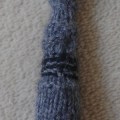 A knitted version of the Fourth Doctor's sonic screwdriver. It's grey with black and red detailing.