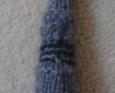 A knitted version of the Fourth Doctor's sonic screwdriver. It's grey with black and red detailing.
