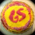 photo of the top of a cupcake with bright yellow icing and the initials GS