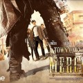 A movie-style poster in Wild West fashion for *A Town Called Mercy* - everything is rendered in a dusty overlay. We see a pair of trousered and booted legs in gunfighter wide stance, but the arm hanging beside where we expect to see a gun holster is instead some sort of cyber-cannon. Through the legs we see the Doctor, Amy and Rory staring the gunfighter down.