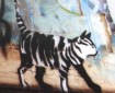 a photo of a stencil-art stripey cat on a brick wall in Newtown