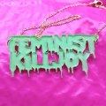 Picture of a pendant enamelled with the words "Feminist KillJoy" in a Tales from the Crypt comic style