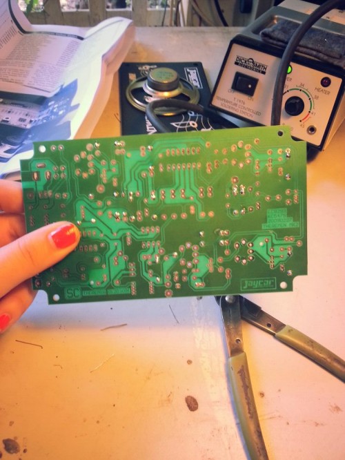 A hand holding a printed circuit board.