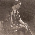 Sepia photo portrait of Marion Mahony, in her 30s, seated, wearing an artist's smock.