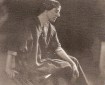 Sepia photo portrait of Marion Mahony, in her 30s, seated, wearing an artist's smock.