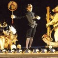 Puppet Shakespeare behind footlights, with a large basket full of props, and a cutout bear.