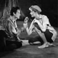 B&W photo of Vanessa Redgrave in cutoff pants and cloth cap, playing Rosalind, with her Orlando.