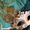 white and gold carnival mask on green silk