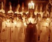 Group of girls holding candles, one at the front wearing a candle crown.