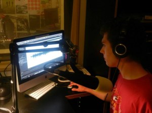 Young white man in headphones with radio recording equipment.