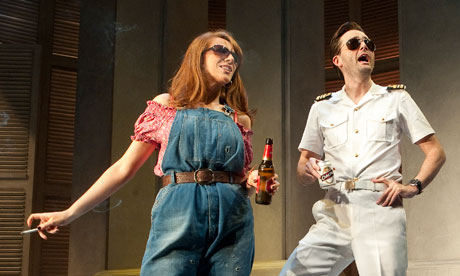 Tate in overalls, smoking, Tennant in naval whites, both with sunglasses.