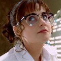 Zooey Deschanel in lab coat and glasses.