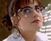 Zooey Deschanel in lab coat and glasses.