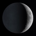 a photograph of Earth's moon showing a brightly sunlit crescent contrasted against the finally earthlit rest of the surface
